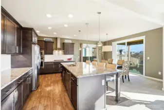 Stainless steel appliances mix with granite and custom wood cabinets throughout the kitchen.