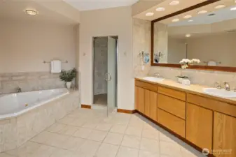 Primary en suite w/ corner soaking tub and large walk-in tile shower.