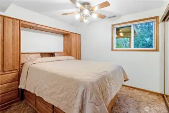 Lower level bedroom window overlooking backyard greenery.