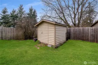 Detached backyard shed providing additional storage for tools, lawn equipment or outdoor gear.