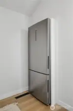 Kitchen area with full-size refrigerator and storage