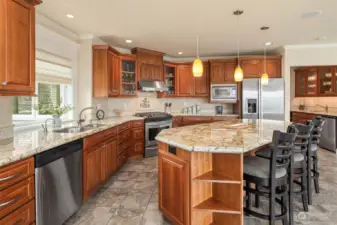 An abundance of cabinetry, sparkling countertops, stainless appliance, and a large center island complement this kitchen.