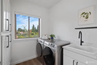 2nd floor laundry room includes full wall of cabinets s=for storage, extra large laundry sink with quartz counters & workspace. Front load washer and dryer included.