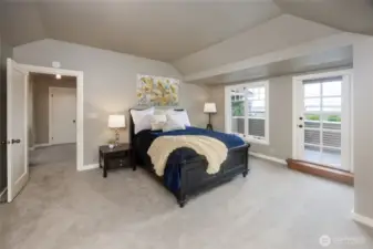 Luxurious primary suite offers a balcony with lake views.