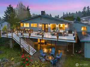 Rear view of giant deck perfect for entertaining! daylight basement and bonus room behind garage really highlight the size of the house that isn't as obvious from the front.