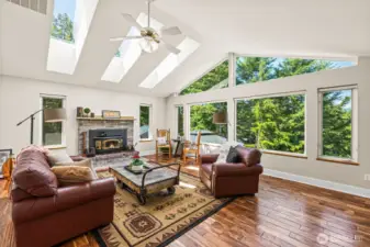 Living room with so much natural light and stunning views. Cozy fireplace that has been inspected yearly, natural stone mantle.