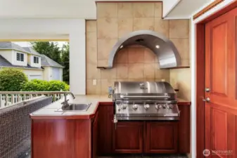 The outdoor kitchen is custom designed with top of the line gas BBQ and venting.
