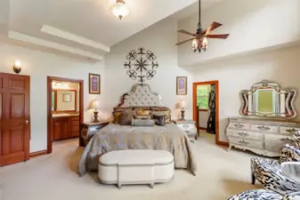 The main floor primary bedroom suite has vaulted ceilings giving it an expansive feel.