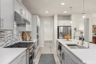 A useful mud room and walk in pantry frame the kitchen
