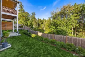 The south side of the yard provides a greenbelt and terraced gardens below.