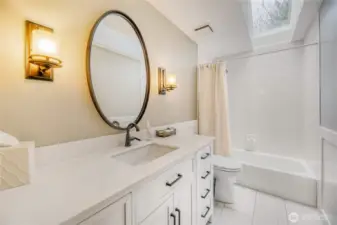 Guest bathroom.  Quartz counter tops, tiled floor, soft closed doors on cabinets,another toto toilet, and sky light.