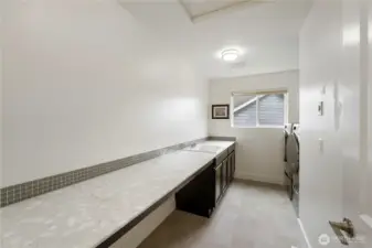 Upper-level laundry room with built-in cabinetry and a convenient utility sink