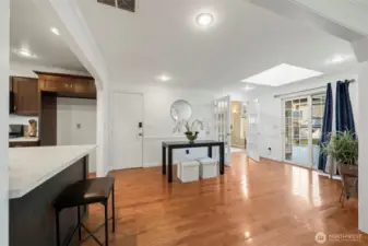 Looking into the secondary great room opens with vaulted ceilings and abundant windows, while skylights throughout the dining area and home bring in beautiful natural light. Sliding glass door leads directly to the expansive deck, extending the living space outdoors for easy entertaining.