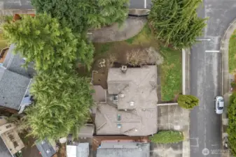 Aerial view showing the home’s setting on a spacious lot with mature trees and established neighborhood surroundings.