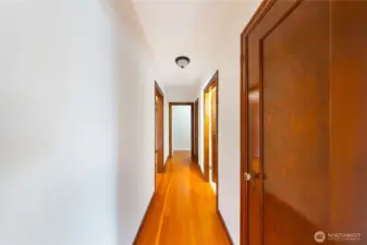 Hallway with entrances to main floor full bath, primary hallway and office.
