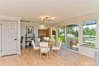 The dining area can comfortably accommodate a large dining table and is an ideal setting for holidays and entertaining. A sliding door opens to the covered deck for seamless indoor-outdoor living.