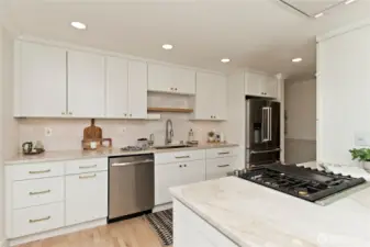 Premium JennAir and KitchenAid appliances throughout. Under-cabinet lighting enhances workspace visibility.