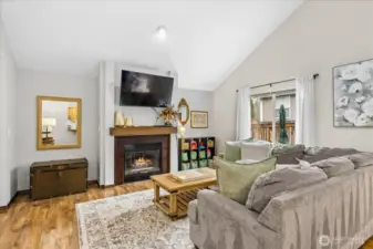 Open concept living on the lower level with laminate floors throughout and a cozy gas fireplace in the living room.