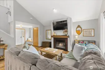 Open concept living on the lower level with laminate floors throughout and a cozy gas fireplace in the living room.
