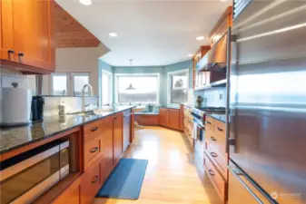 Kitchen with straight grain fir cabinets and oak hardwood floors looking towards the eating nook and view