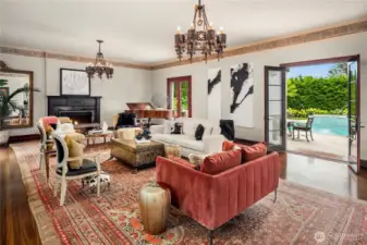 The "sunken" living room is anchored on one end by a beautiful fireplace, and double French doors lead out to the patio and pool.