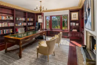 The main floor library/office sits directly behind the foyer, and in-between the living and dining room. On-point leaded windows showcase the lovely gardens & patios and walls of bookshelves provide elegant storage for your book collection.