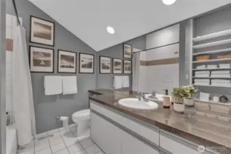 Attached full bath features tiled shower/tub and floors; granite countertop; huge linen storage closet