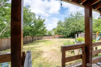 From covered patio, welcome to this beautiful back yard