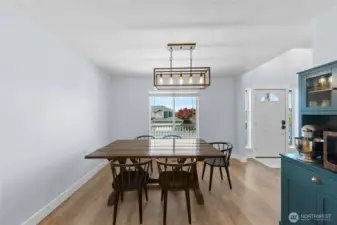 Dining room has updated light fixture, incredible natural light, and is open to the kitchen.