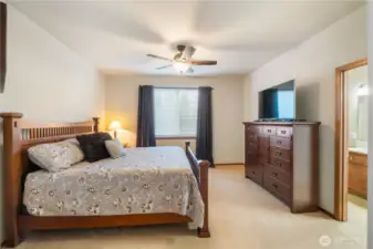 The spacious primary bedroom is a true retreat and offers a decorative ceiling fan light