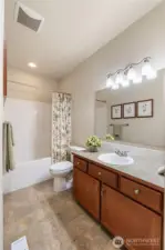The main bath includes a roomy bathtub and linens storage to the right