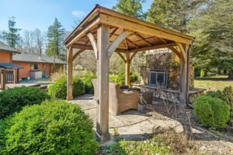 Covered gazebo offering a relaxing outdoor retreat, with an outdoor fireplace