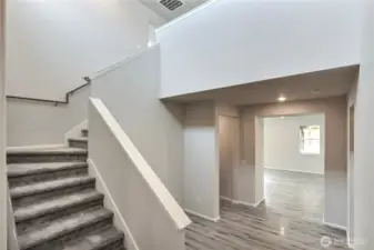 Staircase going up.  Door way to closet under stairs and entry to the garage.  on the right is the door to the 1/2 bath and the MIL apartment.