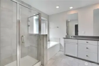 Primary bathroom includes dual vanities, spacious shower and garden tub.