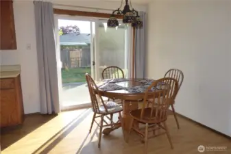 Bright dining room with slider to fenced backyard and patio.