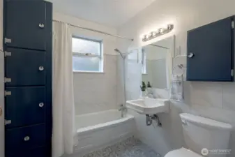 Bathroom with porcelain penny round tile on floor and large porcelain subway tile on walls. More custom built-ins and medicine cabinet for ample storage.