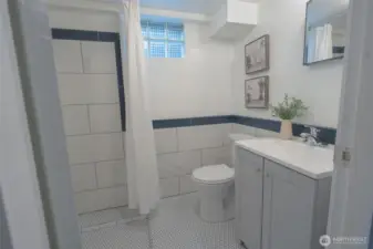 3/4 bathroom in basement with all new fixtures, porcelain penny round tile on floors and large porcelain subway tile on walls.