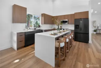 A sleek waterfall island provides generous space for casual meals and easy gathering