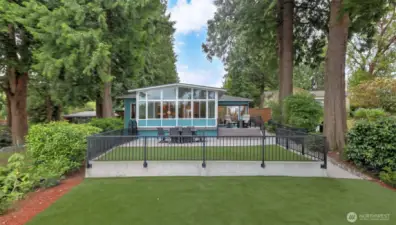 Standing near the edge of the lake you see a perfectly maintained yard with a private primary suite patio a second patio that is and level fully fenced in, and a 3rd space just prior to the lake. Dream Turf synthetic lawn keeps the area clean dry and useable all year.