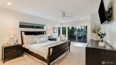 Large primary suite with lake views and a motorized shade for privacy and to filter the sun. The sliding leads to a private patio.