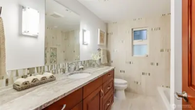 Gorgeous full hall bath with opulent tile work and accents.