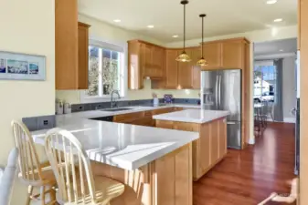 Beautiful kitchen with maple cabinets, stainless appliances, composite counters, eating bar, built in desk space, and a pull-out pantry cabinet.