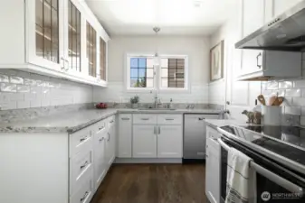 Top-of-the-line kitchen with quartizite counters, custom cabinets, stainless appliances and rich hardwoods.