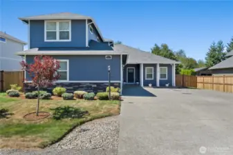 Inviting curb appeal with cement-plank and stone-accented siding, fresh landscaping, and a wide driveway for ample parking.