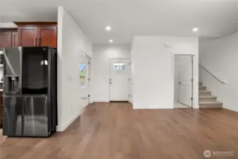 Bright and inviting entryway with warm hardwood floors, modern recessed lighting, and an open layout that seamlessly connects to the main living spaces.