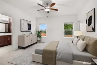 Spacious primary bedroom with plush carpeting, ceiling fan, and large windows overlooking the backyard, complete with an en-suite bath and large walk-in closet. Virtually staged.