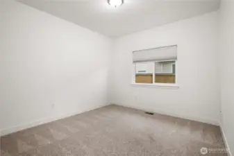 Second of the two non-primary bedrooms with plush carpeting and a large window for natural light.