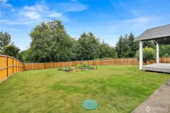 Expansive backyard with a fenced garden area, lush lawn, and plenty of space for outdoor activities.