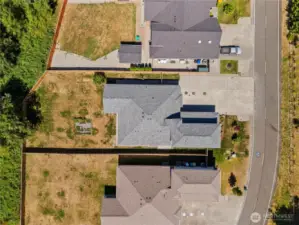 Top-down aerial view showcasing the home’s generous lot, private fenced backyard, and peaceful greenbelt surroundings.