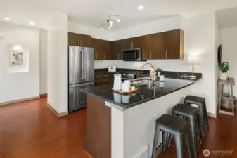 Spacious kitchen with gas range, abundance of cabinets, stainless appliances, and breakfast bar.